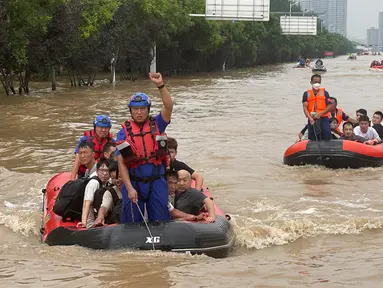 Warga dievakuasi menggunakan perahu karet melalui banjir di Zhuozhou, Provinsi Hebei, China, Rabu (2/8/2023). Otoritas China menggandakan upaya penyelamatan di Kota Zhuozhou, salah satu kawasan terdampak banjir dengan lebih dari 600.000 penduduk di barat daya Beijing. (AP Photo/Andy Wong)