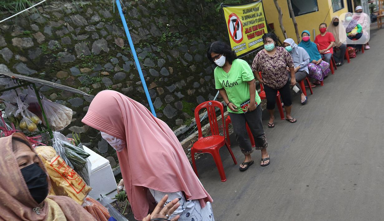 Calon pembeli mengantre dengan menerapkan pembatasan jarak fisik atau physical distancing di Taman Anyelir 3, Depok, Selasa (28/4/2020). Penerapan jaga jarak fisik dilakukan agar tidak terjadi penumpukan pelanggan sebagai upaya pencegahan penyebaran COVID-19. (Liputan6.com/Herman Zakharia)