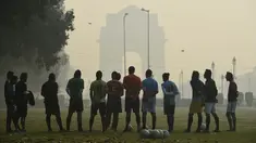 Sejumlah pria mendengarkan pelatih sebelum bermain sepak bola di tengah kondisi kabut asap tebal di New Delhi, India (30/10). Tingkat kabut melonjak selama musim dingin di Delhi, ketika kualitas udara memburuk. (AFP Photo/Prakash Singh)