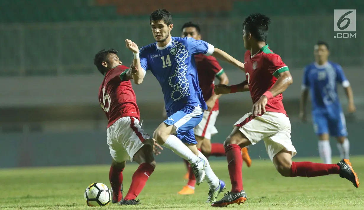 Dua pemain Indonesia U-23 mencoba menahan pergerakan pemain Uzbekistan pada laga PSSI Anniversary 2018 di Stadion Pakansari, Kab Bogor, Kamis (3/5). Babak pertama berakhir imbang 0-0. (Liputan6.com/Helmi Fithriansyah)
