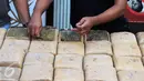 Petugas Dir IV Narkoba Mabes Polri memperlihatkan barang bukti ganja saat rilis di Jakarta, Selasa (24/5/2016). Petugas menahan enam orang tersangka dengan barang bukti narkoba jenis ganja seberat satu ton. (Liputan6.com/Helmi Fithriansyah)