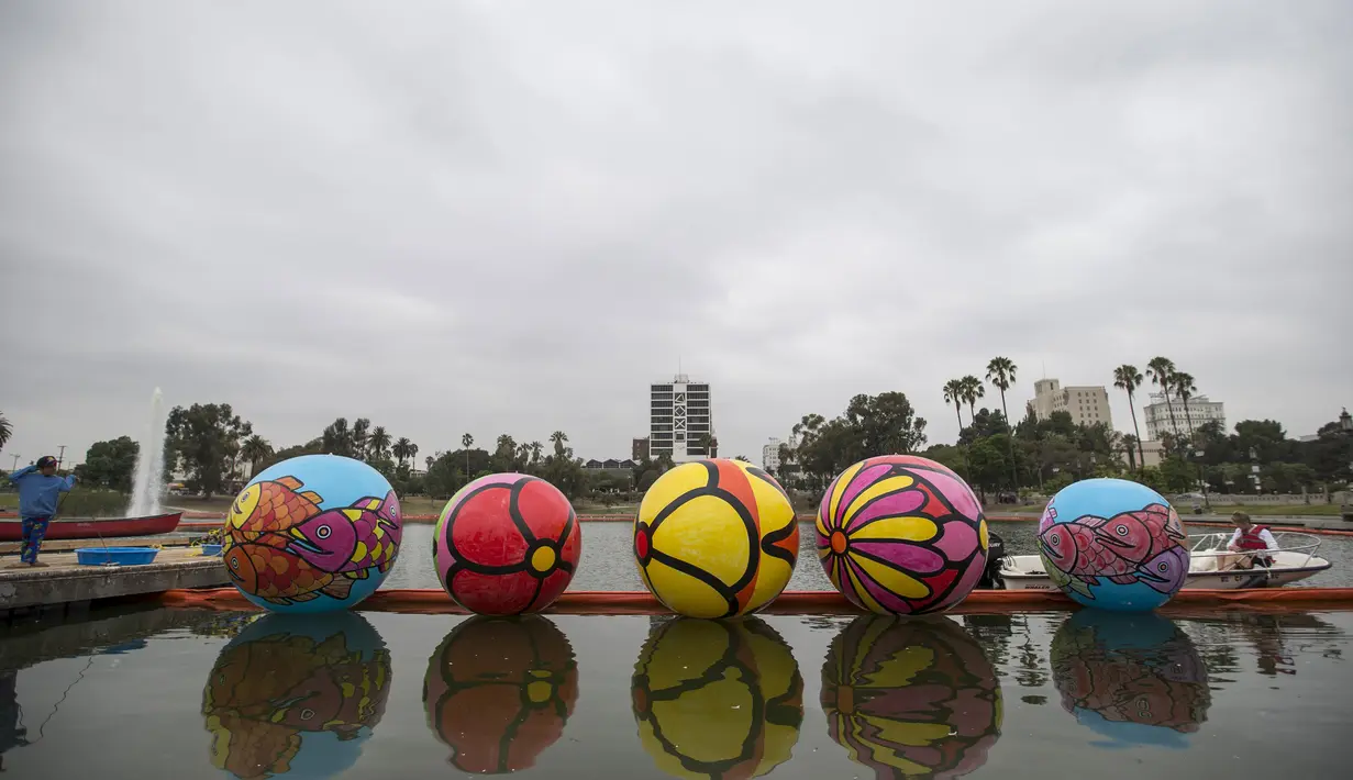 Sejumlah bola raksasa tertata rapih di danau MacArthur Park selama pameran "Spheres" di Los Angeles, California, AS (21/8/2015). Acara ini menampilkan sekitar 3.000 bola raksasa yang dihias oleh para relawan. (REUTERS/Mario Anzuoni)