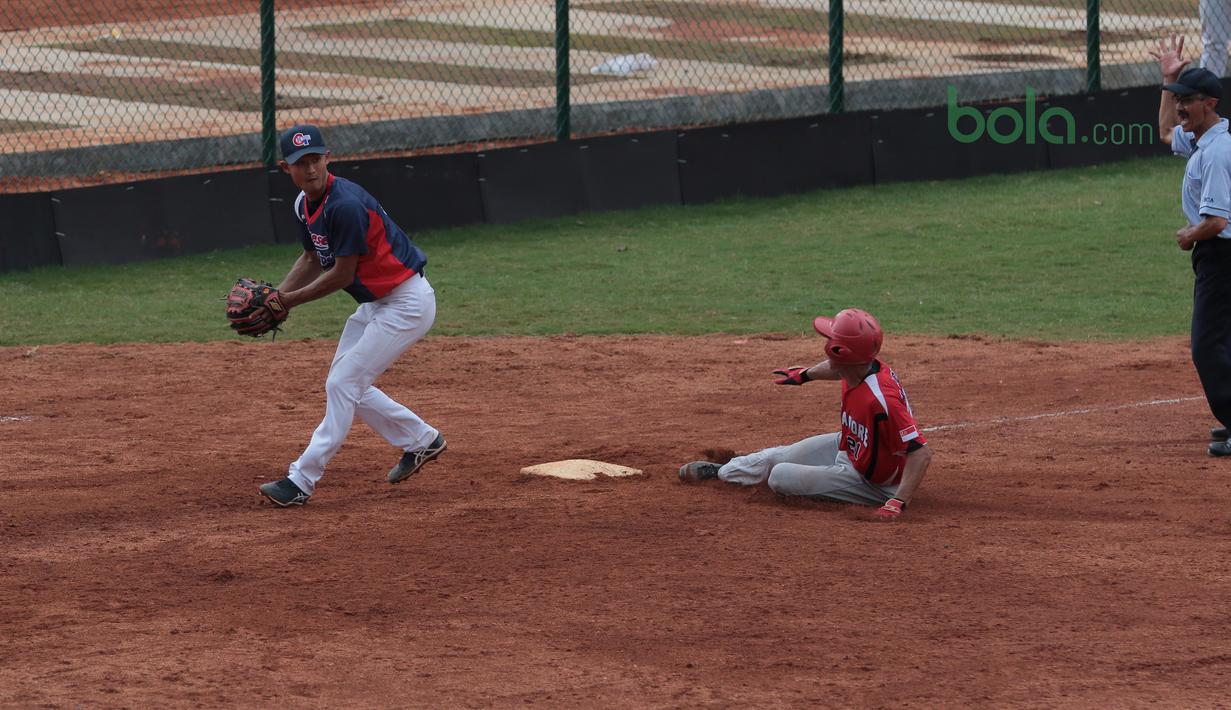 Pemain Singapura (tengah) menggapai base saat melawan Taiwan pada laga Asian Softball Championship di Senayan, Jakarta,Selasa (24/4/2018). Singapura menang 12-4. (Bola.com/Nick Hanoatubun)