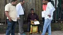 Sejumlah pria menunggu juru ketik menyelesaikan ketikannya di Mumbai, India (3/8). Sekitar 3.500 institut di negara bagian Maharashtra  yang masih menggunakan mesin tik manual akan diganti dengan komputer. (AFP Photo/Indranil Mukherjee)