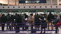 Wisatawan mempersiapkan dokumen mereka saat mengantre di meja imigrasi bandara internasional Roissy Charles-de-Gaulle, Paris, Senin (1/2/2021). Selain "alasan luar biasa", semua perjalanan penting dari luar Uni Eropa telah dilarang di Prancis. (AP Photo/Francois Mori)