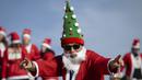 Seorang pelari berkostum Sinterklas berpose saat bersiap dalam acara fun run 5 km pada Minggu (22/12/2024) waktu setempat. (AFP/Josep Lago)