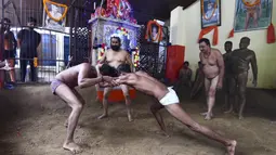 Pegulat beraksi dalam pertandingan gulat tradisional di klub gulat Loknath Vyayamsala di Prayagraj, India, (21/8/2023). Acara tersebut untuk merayakan festival Hindu Nag Panchami. (AFP/Sanjay kanojia)