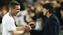 Gelandang Jerman, Lukas Podolski, berbincang dengan pelatih Jerman, Joachim Loew. Podolski turut menjadi bagian dari skuat Jerman saat menjuarai Piala Dunia 2014 di Brasil. (EPA/Friedmann Vogel)