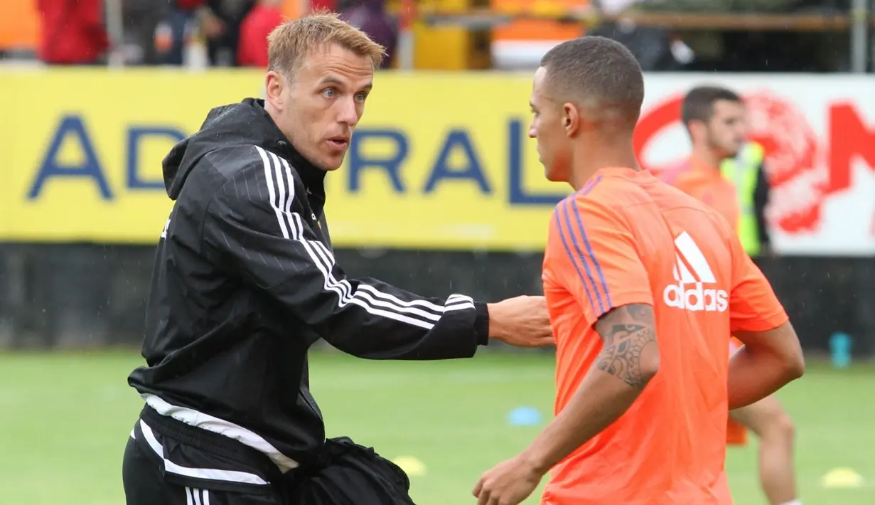 Asisten pelatih Valencia, Phil Neville, memberikan arahan kepada Rodrigo saat pemanasan. (Bola.com/Reza Khomaini)
