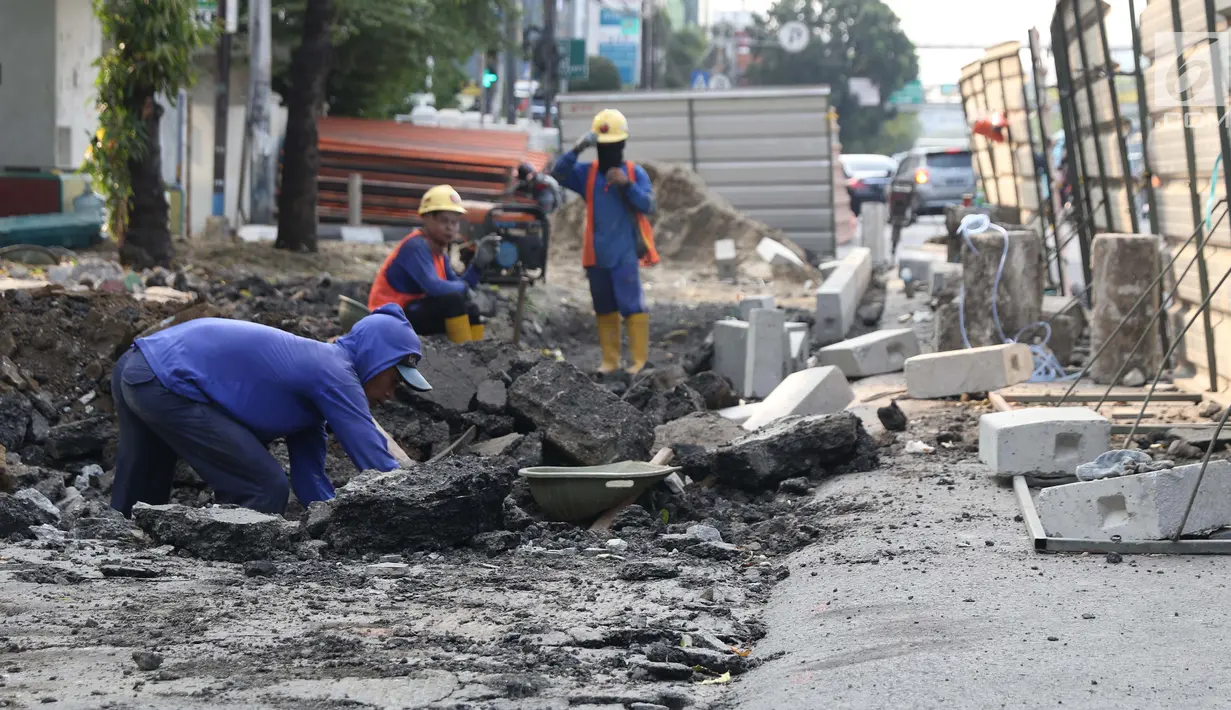 Aktivitas pekerja menyelesaikan proyek revitalisasi trotoar di Jalan Salemba Raya, Jakarta, Jumat (6/9/2019). Proyek revitalisasi trotoar dengan anggaran Rp 75 miliar ini ditargetkan rampung pada Desember mendatang. (Liputan6.com/Helmi Fithriansyah)