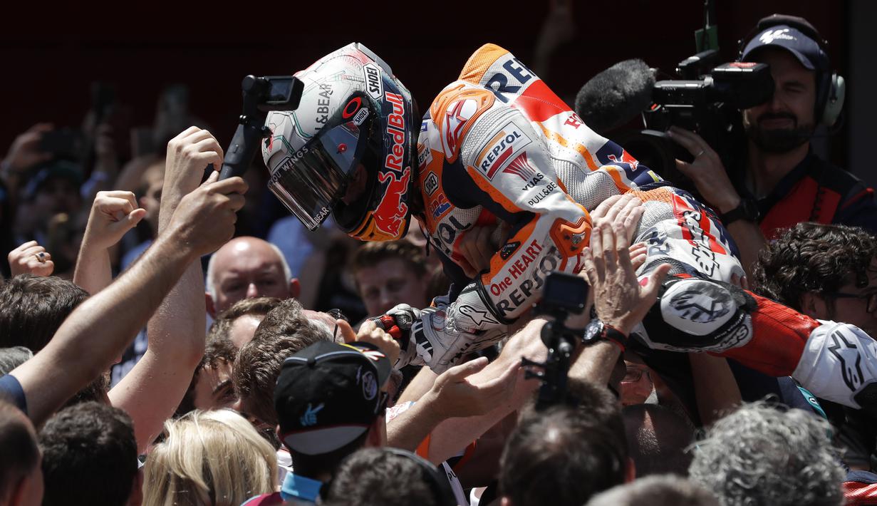 Selebrasi bak penggemar musik rock yang melakukan mosh pit di depan panggung dilakukan Marc Marquez usai menang di Sirkuit Catalunya Barcelona. (AFP/Pau Barrena)