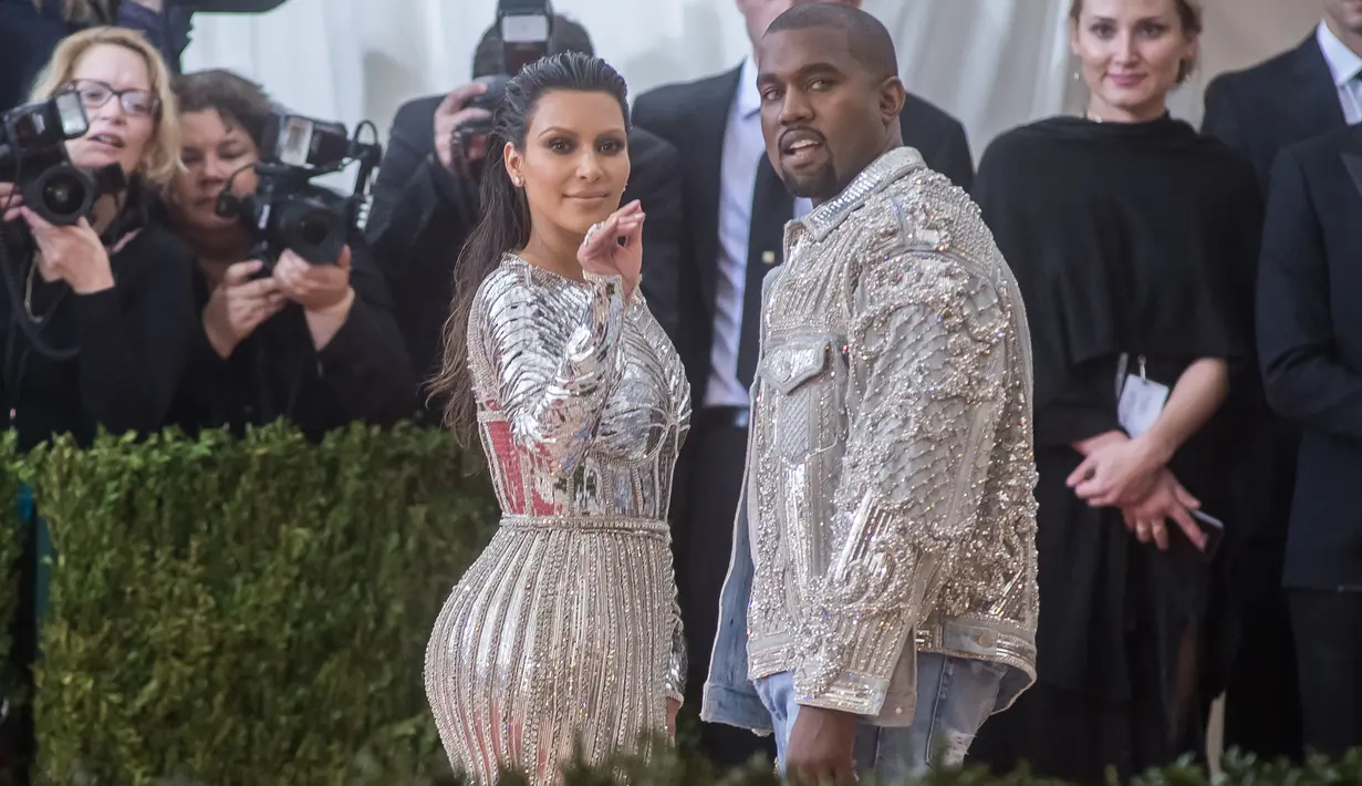 Pasangan Kanye West dan Kim Kardashian mencuri perhatian saat menghadiri ajang Met Gala 2016 di Metropolitan Museum of Art, New York City, Senin (2/5). Keduanya tampil senada mengenakan warna metalik perak. (Mark Sagliocco /Getty Images/AFP)