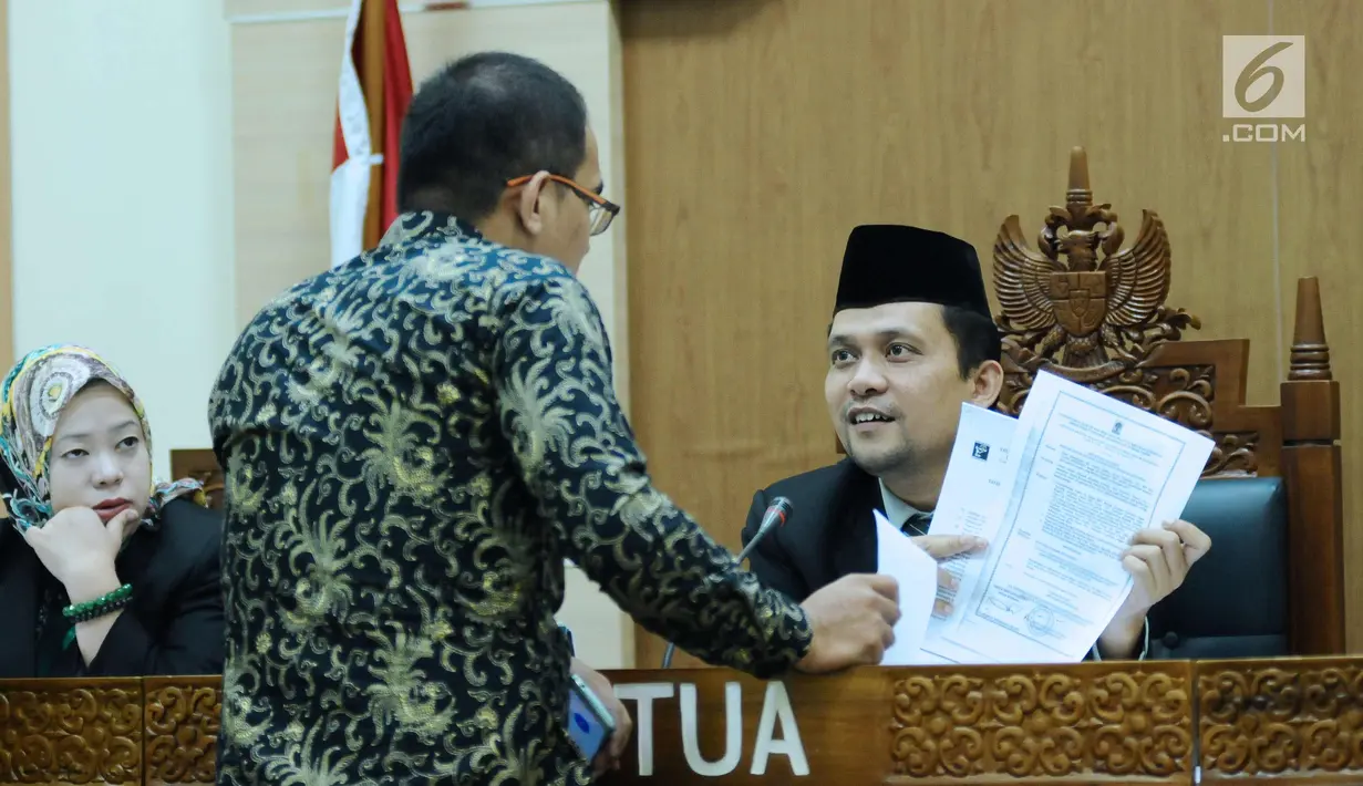 Ketua Majelis sidang sengketa informasi publik terhadap Kementerian LHK, Hendra J Kede (kanan) memeriksa kelengkapan berkas bersama asisten bantuan hukum LBH Jakarta, Abraham Nempung di Gedung KIP, Jakarta, Kamis (1/3). (Liputan6.com/Helmi Fithriansyah)