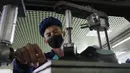 Seorang pekerja yang memakai masker saat bekerja di Pabrik Sepatu Kulit Wonsan, tempat memproduksi sepatu kulit buatan tangan di Wonsan, Provinsi Kangwon, Korea Utara pada 28 Oktober 2020. (AP Photo/Jon Chol Jin)