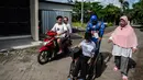 Petugas Kelompok Penyelenggara Pemungutan Suara (KPPS) berkostum superhero Captain America membantu warga berkursi roda yang akan mencoblos dalam Pemilu 2019 di sebuah TPS di Surabaya, Jawa Timur, Rabu (17/4). (Juni Kriswanto/AFP)