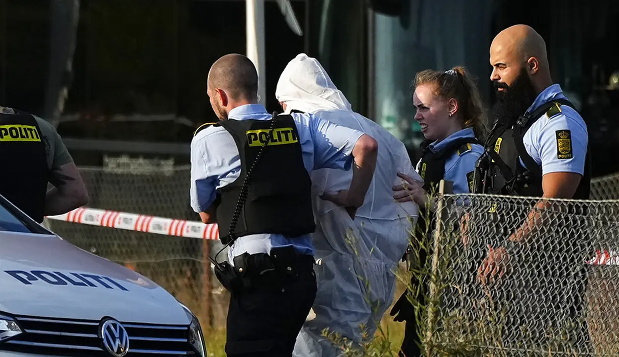 Seseorang dengan setelan APD putih dibawa pergi oleh polisi dekat pusat perbelanjaan Field setelah penembakan di Kopenhagen, Denmark, 3 Juli 2022. Sejauh ini hanya ada satu tersangka. (Claus Bech/Ritzau Scanpix via AP)