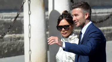 Mantan gelandang Real Madrid David Beckham dan istrinya Victoria Bekcham tiba di gereja menghadiri upacara pernikahan bek Sergio Ramos dan Pilar Rubio di Katedral Seville, Spanyol (15/6/2019). (AFP Photo/Cristina Quicler)