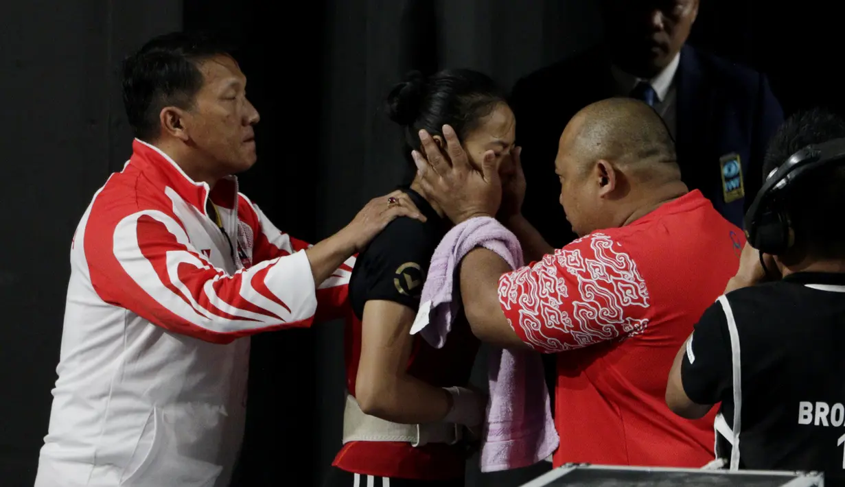 Lifter Windy Aisyah bersiap melakukan angkatan saat SEA Games 2019 cabang angkat besi nomor 49 kg di Stadion Rizal Memorial, Manila, Minggu (1/12). Dirinya meraih emas dengan total angkatan 104 kg. (Bola.com/M Iqbal Ichsan)