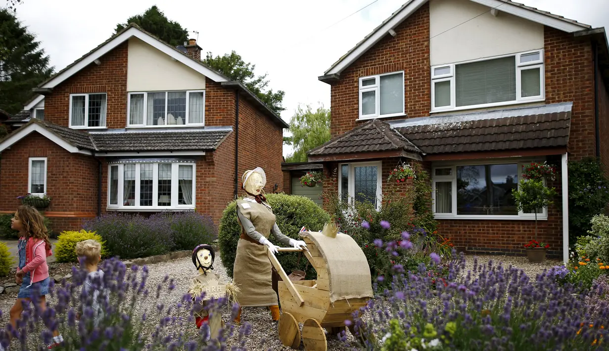 Sebuah orang-orangan sawah dari Pangeran George dan Putri Charlotte serta pengasuh mereka berdiri di sebuah taman saat Festival Scarecrow di Heather, Inggris, 28 Juli 2015. (REUTERS/Darren Staples)