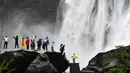 Sejumlah wisatawan mengamati air terjun Chishui di Kota Zunyi, Provinsi Guizhou, China barat daya (7/10/2020). Terkenal karena kekayaan sejarah dan sumber daya alamnya, Kota Zunyi menarik banyak wisatawan selama libur Hari Nasional dan Festival Pertengahan Musim Gugur. (Xinhua/Yang Wenbin)