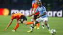 Striker Manchester City, Raheem Sterling, berusaha melewati pemain FC Shakhtar Donetsk pada laga Liga Champions di Stadion Metalist, Rabu (18/9/2019). Manchester City menang 3-0 atas FC Shakhtar Donetsk. (AP/Efrem Lukatsky)