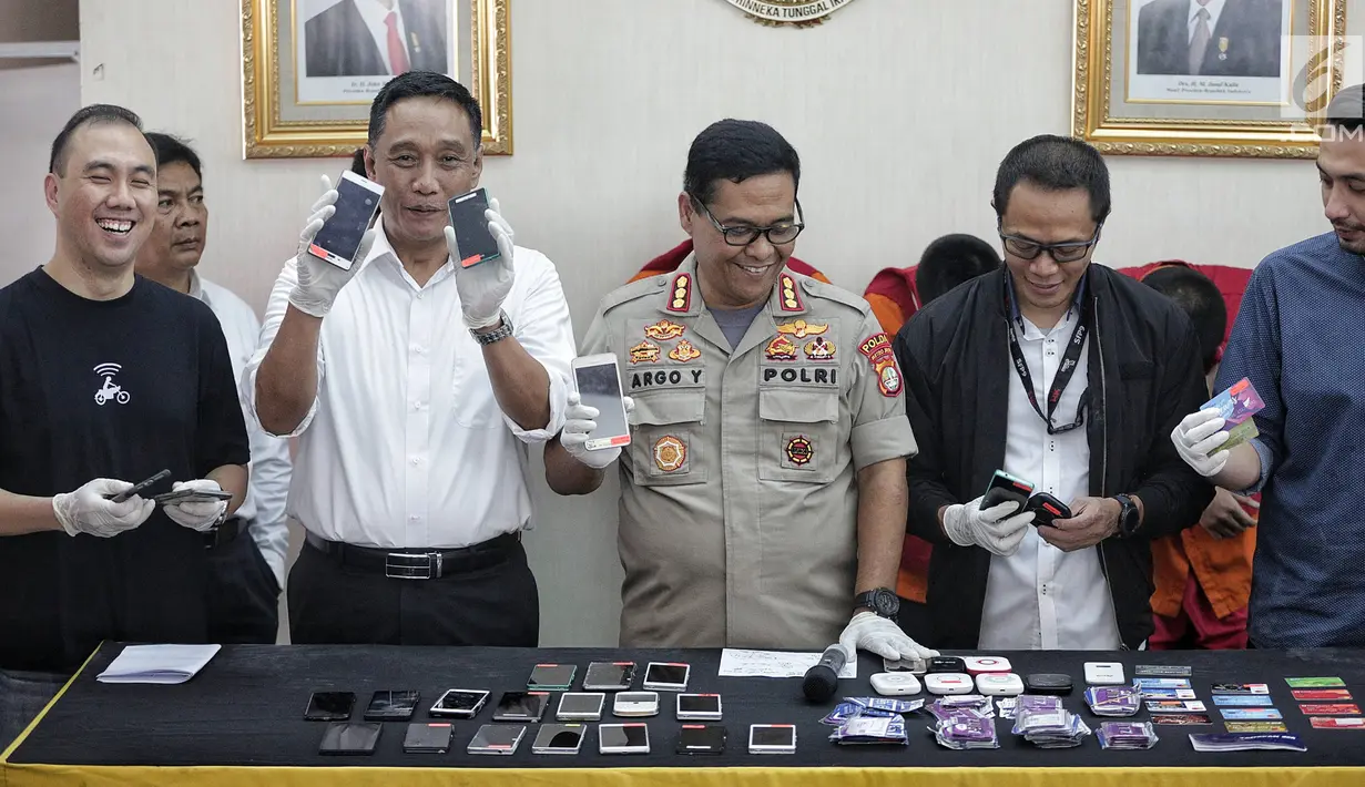 Kabid Humas Polda Metro Jaya Kombes Pol Argo Yuwono menunjukkan barang bukti kasus order fiktif pada transportasi online di Polda Metro Jaya, Jakarta, Rabu (13/2). Kasus ini diungkap oleh Satgas Cyber Crime Polda Metro Jaya. (Liputan6.com/Faizal Fanani)