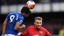 Bek Manchester United, Luke Shaw, duel udara dengan striker Everton, Dominic Calvert-Lewin, pada laga Premier League di Stadion Goodison Park, Minggu (1/3/2020). Kedua tim bermain imbang 1-1. (AFP/Paul Ellis)