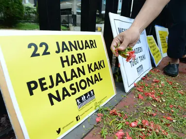 Aktivis Koalisi Pejalan Kaki tabur bunga untuk memperingati Hari Pejalan Kaki Nasional di kawasan Tugu Tani, Jakarta, Selasa, (22/1). Acara ini sekaligus mengenang 9 pejalan kaki yang gugur akibat kecelakaan pada 2012 lalu. (Merdeka.com/Imam Buhori)