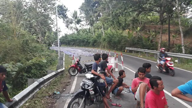 Warga turut berjaga di jalan yang ambles. (Foto: Liputan6.com/Muhamad Ridlo)