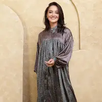 Ririn Ekawati tampil dengan gamis warna ungu pada bagian atas dan hijau bagian bawah, memiliki motif daun coklat. [@ririnekawati]