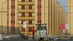 Penjual jus berdagang di depan gerbang proyek rumah susun Tahya Misr di Al-Asmarat, Kairo, Mesir, 2 Juni 2016. Presiden Abdel Fattah al-Sisi berjanji memindahkan mereka yang tinggal di daerah kumuh ke perumahan pemerintah. (REUTERS/Amr Abdallah Dalsh)