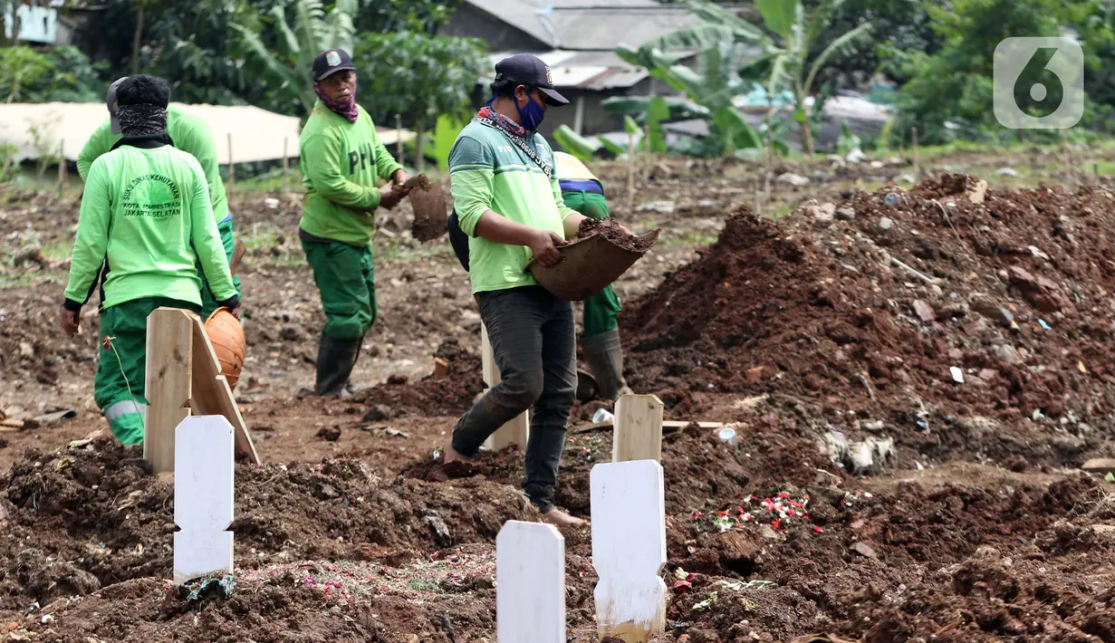 Petugas menyiapkan dan merapikan area khusus pemakaman jenazah dengan protokol COVID-19 di TPU Srengseng Sawah Dua, Jakarta, Selasa, (2/2/2021). TPU Srengseng Sawah 2, saat ini mulai menerima pemakaman jenazah protokol COVID-19 dengan kapasitas 1.020 petak. (Liputan6.com/Helmi Fithriansyah)