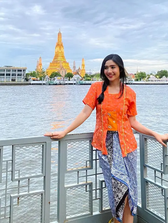 Gaya liburan super manis dari Febby Rastanty. Di foto ini, ia tampil mengenakan kebaya oranye, yang dipadu dengan kain batik bernuansa biru yang serasi. [Foto: Instagram/febbyrastanty]