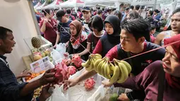 Warga membeli buah-buahan murah pada acara Family Day Artha Graha Peduli (AGP) di Pasar Akhir Pekan SCBD, Jakarta, Minggu (25/11). Acara ini diawali dengan fun walk dan fun run yang diikuti 5000 peserta. (Liputan6.com/Fery Pradolo)