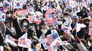 Para pendukung Presiden Korea Selatan yang dimakzulkan, Yoon Suk Yeol, melambaikan bendera Amerika Serikat dan Korea Selatan saat mereka berkumpul di dekat kediaman kepresidenan di Seoul pada tanggal 31 Desember 2024. (JUNG YEON-JE/AFP)