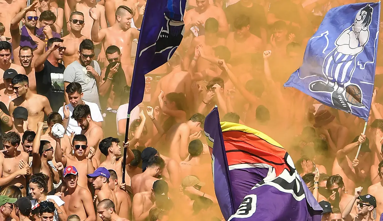 Para suporter Fiorentina menyalakan flare saat melawan Juventus pada laga Serie A di Stadion Artemio Franchi, Florence, Sabtu (14/9). Kedua klub bermain imbang 0-0. (AFP/Vincenzo Pinto)