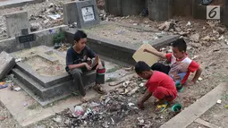 Anak-anak bermain layang-layang di TPU Menteng Pulo, Jakarta, Kamis (18/10). Padatnya pemukiman penduduk serta gedung bertingkat di kawasan tersebut menyebabkan anak-anak terpaksa bermain di tempat yang tidak semestinya. (Liputan6.com/Immanuel Antonius)