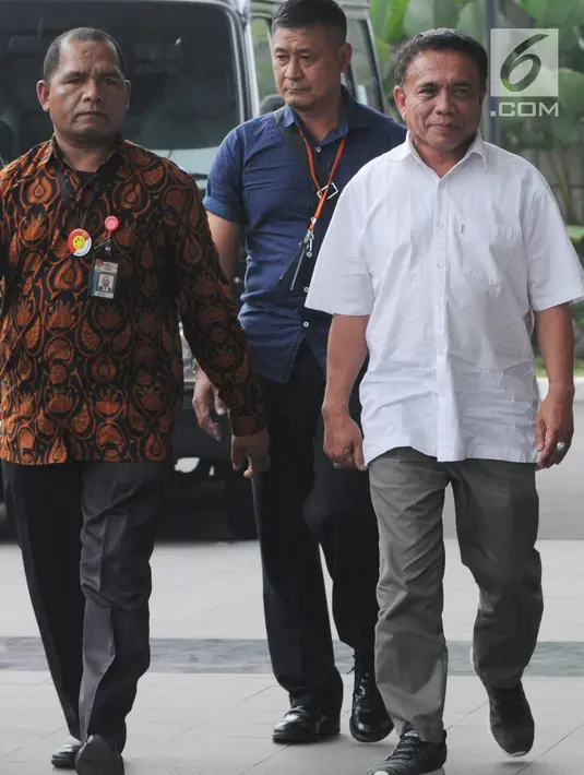 Gubernur Aceh Irwandi Yusuf didampingi petugas tiba di Gedung KPK, Jakarta, Rabu (4/7). Ketua Umum Partai Nanggroe Aceh (PNA) itu enggan memberikan komentar terkait penangkapannya. (Merdeka.com/Dwi Narwoko)