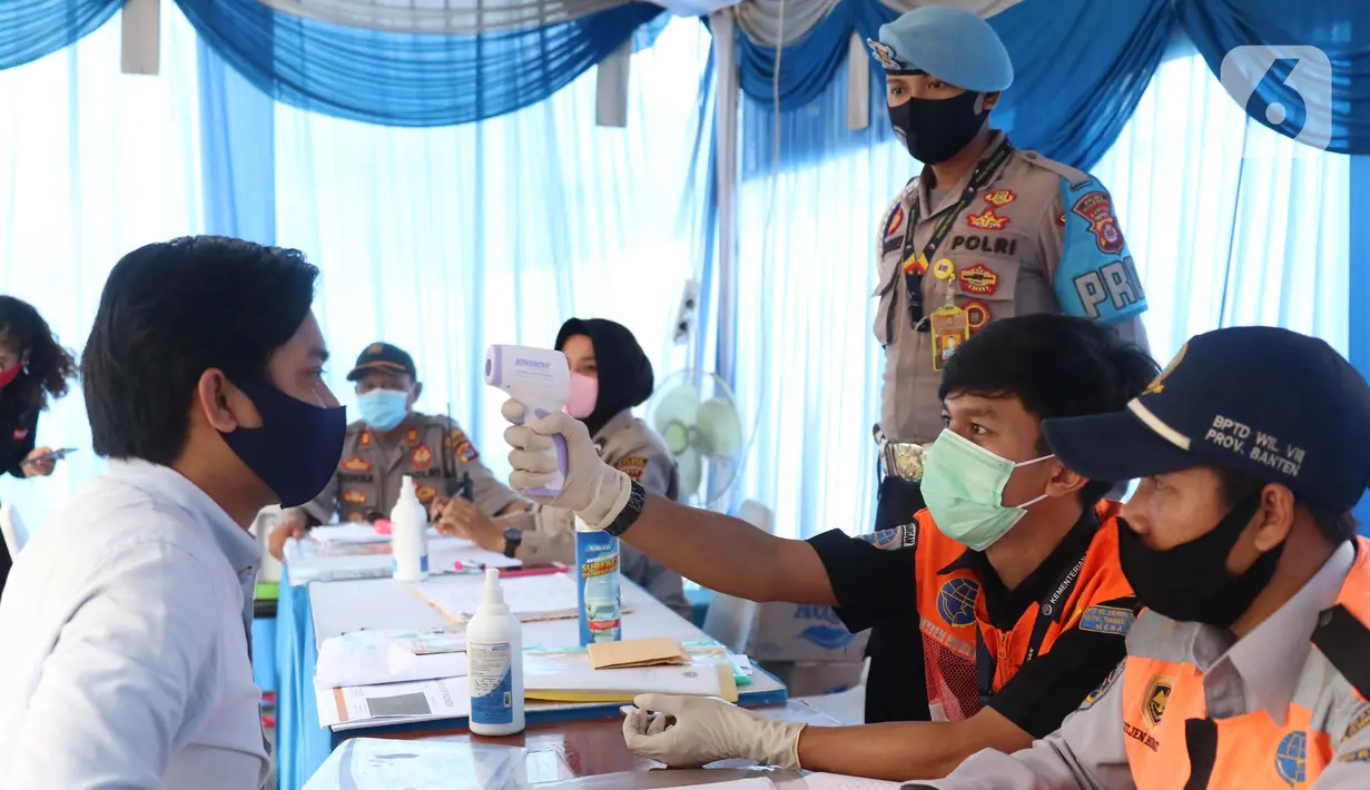 Petugas mengecek suhu penumpang yang menaiki kapal ferry saat pemeriksaan dokumen di Pelabuhan Merak, Banten, Senin (18/5/2020). Penumpang harus memenuhi sejumlah persyaratan ketat mencakup standar kesehatan dan verifikasi dokumen guna memutus rantai penyebaran COVID-19. (Liputan6.com/Angga Yuniar)