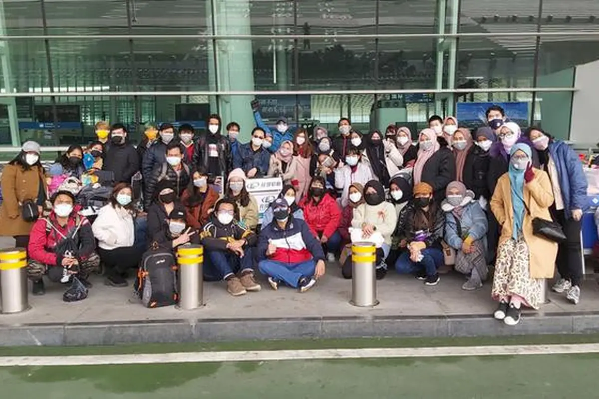 Sejumlah Warga Negara Indonesia (WNI) yang akan dievakuasi berpose bersama di Bandara Internasional Tianhe, Wuhan, Hubei, China, Sabtu, (1/2/2020).