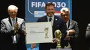 Presiden Paraguay, Alejandro Dominguez (tengah) memegang sertifikat yang mengesahkan Argentina, Paraguay, dan Uruguay sebagai negara tuan rumah Piala Dunia FIFA 2030 selama Kongres virtual FIFA di Luque, Paraguay pada 11 Desember 2024. (AFP/Daniel Duarte)