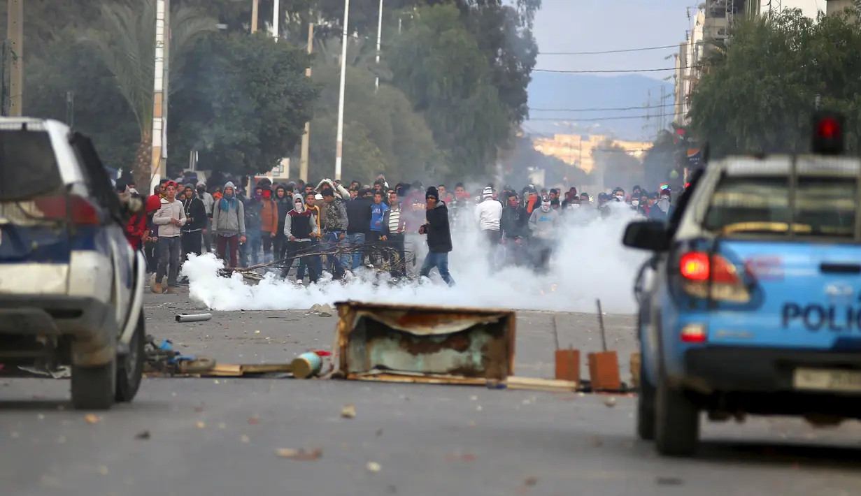 Polisi menembakkan gas air mata ke arah pengunjuk rasa di luar kantor pemerintah setempat di Kasserine, Tunisia, Kamis (21/1). Para pengangguran muda turun ke jalan memprotes keterpurukan ekonomi dan sulitnya lapangan kerja. (REUTERS/Amine Ben Aziza)