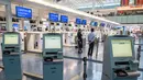 Staf maskapai penerbangan menunggu di konter check-in yang kosong di Terminal Internasional Bandara Haneda setelah penerbangan dibatalkan atau ditunda karena badai tropis Jangmi di Tokyo, Jepang, Rabu 3 Juni 2026. (Andrew CAALLERO-REYNOLDS/AFP)
