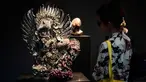 Seorang pengunjung sedang melihat patung yang berjudul "Two Garudas" karya seniman Inggris, Damien Hirst saat pameran di Venice, Italia (6/4). Karya patung tersebut terbuat dari logam yang dibalut dengan terumbu karang. (AFP Photo/Miguel Medina)