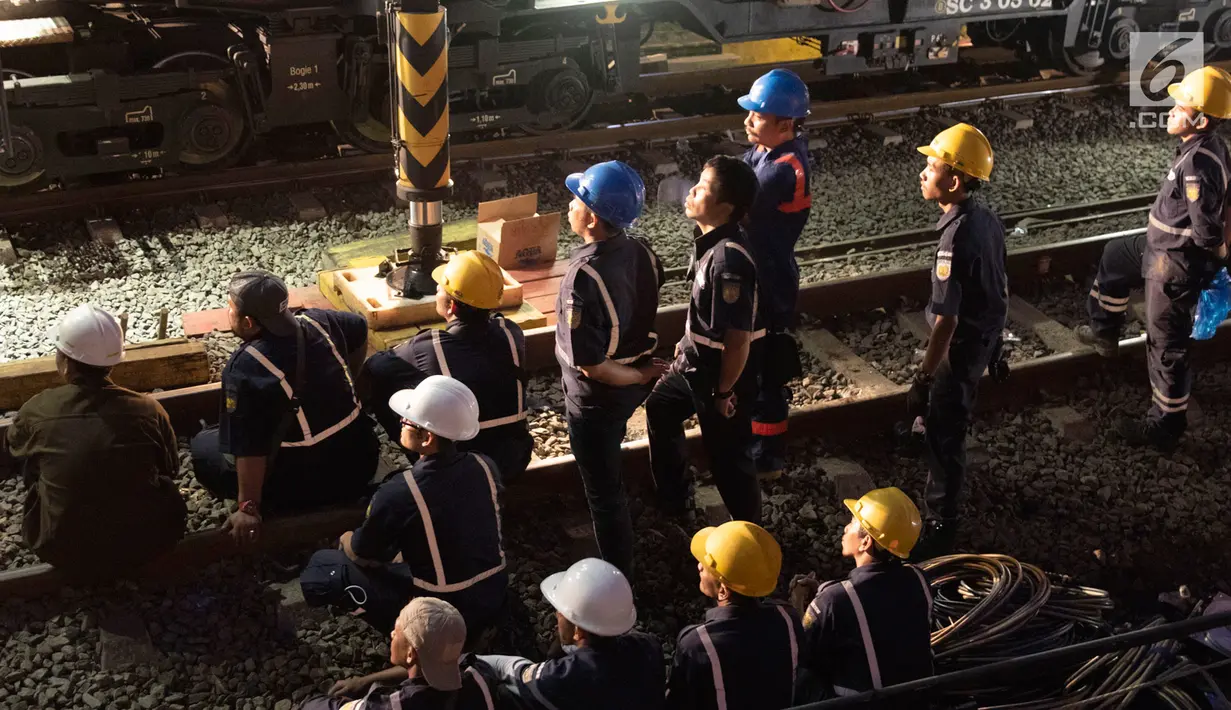 Petugas melihat proses evakuasi gerbong KRL Commuter Line dengan nomor KA 1722 jurusan Jatinegara - Bogor di kawasan Kebon Pedes, Bogor, Jabar Minggu (10/3). Proses evakuasi menggunakan crane dari Bandung. (Liputan6.com/Immanuel Antonius) 