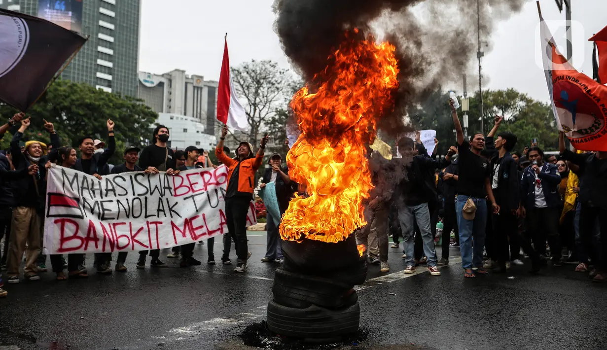 Mahasiswa membakar ban bekas saat demo menolak kenaikan harga Bahan Bakar Minyak (BBM) di kawasan Patung Kuda, Jakarta Pusat (Jakpus), Kamis (8/9/2022). Massa membentuk lingkaran dan menyaksikan ban terbakar. Asap hitam mengepul begitu ban dibakar. (Liputan6.com/Johan Tallo)