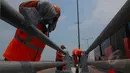 Sejumlah petugas Suku Dinas Pekerjaan Umum  melakukan peremajaan dengan melakukan pengecatan besi pembatas Fly Over di kawasan Cakung, Jakarta,  Rabu (1/4/2015). Panjang pembatas mencapai 120 meter (Liputan6.com/Yoppy Renato)