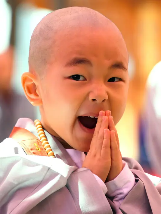 Ekspresi lucu biksu cilik saat ikut upacara Buddha Monks di kuil Jogye, Seoul, Rabu (19/4). Upacara ini digelar menjelang perayaan ulang tahun Buddha yang akan jatuh pada 3 Mei 2017 mendatang. (AFP PHOTO / JUNG Yeon-Je)