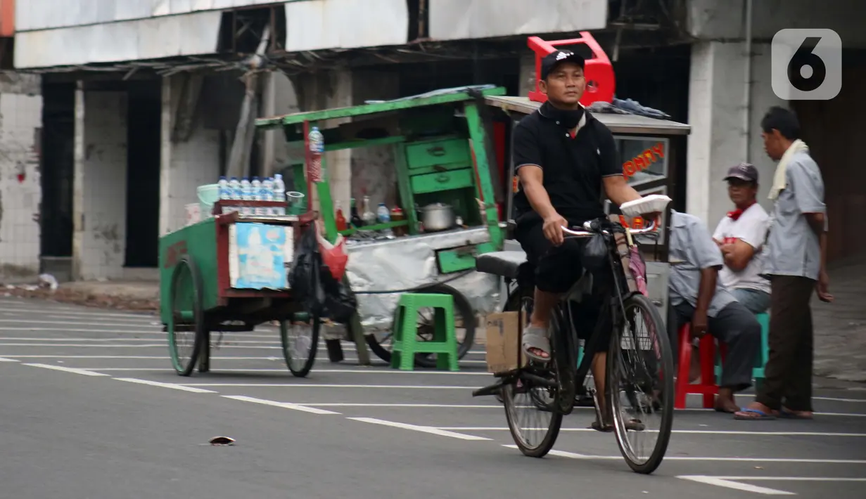 Pengojek sepeda mencari penumpang di kawasan Pasar Asemka, Jakarta, Selasa (21/4/2020). Penghentian sementara aktivitas sebagian besar pertokoan dan perkantoran seiring pelaksanaan WFH dan PSBB berimbas pada sulitnya pengojek sepeda mencari penumpang. (Liputan6.com/Helmi Fithriansyah)