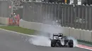 Mobil pebalap Mclaren, Fernando Alonso, mengeluarkan asap saat latihan bebas F1 GP Meksiko di Sirkuit Autodromo Hermanos Rodriguez, Jumat (28/10/2016). (AFP/Yuri Cortez)
